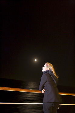 Woman at railing of cruiseship MS Deutschland (Deilmann Cruises) at full moon, South Atlantic Ocean, South America, America