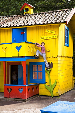 Girl climbing on Pippi Longstocking house, Astrid Lindgren Vaerld, Astrid Lindgren World, Vimmerby, Smaland, South Sweden, Europe