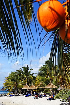 Palm trees and people on the beach of Beachcomber Hotel Paradis &amp;amp; Golf Club, Mauritius, Africa