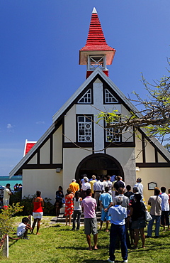 People in front of the Notre Dame Auxiliatrice chapel under blue sky, Cap Malheureux, Mauritius, Africa