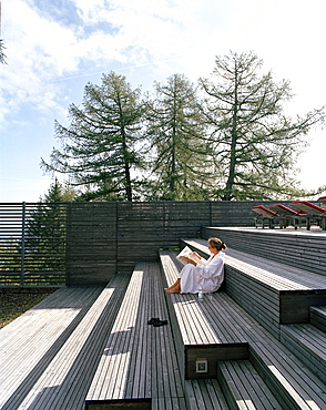 Woman sitting on steps of an terrace, Vigilius Mountain Resort, Vigiljoch, Lana, Trentino-Alto Adige/Suedtirol, Italy