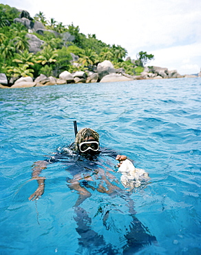 Octopus hunter Alvis Jean snorkeling off FelicitÃˆ island with squid, Coleoidea, La Digue and Inner Islands, Republic of Seychelles, Indian Ocean