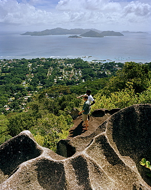 Hikers on granitic rock on the way to Nid d'Aigles lookout point in 300m above sealevel, view over the village La Passe and Praslin Island, central La Digue, La Digue and Inner Islands, Republic of Seychelles, Indian Ocean