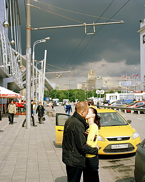 Kissing couple in front of a taxi at Jevropeski Plaza, Moscow, Russia, Europe