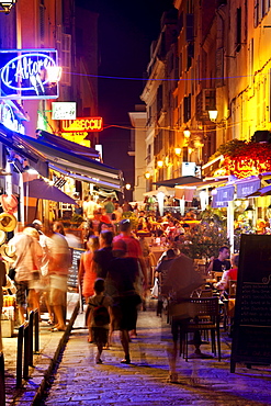 Shops and restaurants at night on Rue Paoli, Ile Rousse, Corsica, France