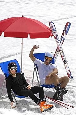 Two skiers in deck chairs in the snow, Alto Adige, South Tyrol, Italy, Europe