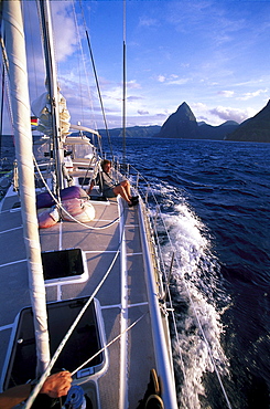 Sailing boat off Deux Pitons island under clouded sky, St. Vincent, Grenadines, Caribbean, America