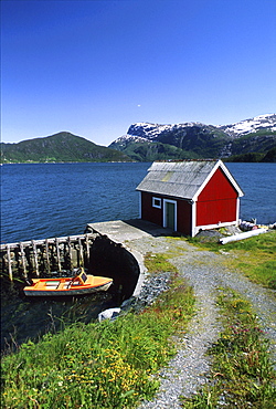 Timber house and jetty at a fjord in the sunlight, Sogn og Fjordane, Norway, Europe