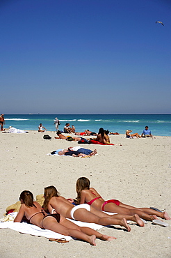 Three young women lying in the sun, beach life, Art Deco Historic Destric, South Beach, Miami, Florida, USA