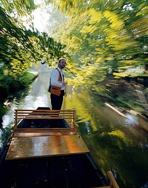 Traditional Spreewald boat in the morning, tourguide Hagen Conrad punting on a stream to pick up tourists in Burg-Kauper, Upper Spreewald, biosphere reservat, Spreewald, Brandenburg, Germany