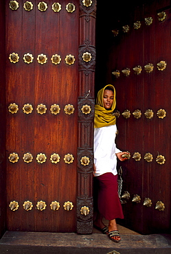 African woman going through a door, Zanzibar, Tansania, Africa