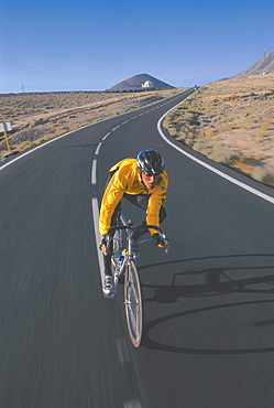 Man on a racing bike riding along a country road, Fuerteventura, Canary Islands, Spain