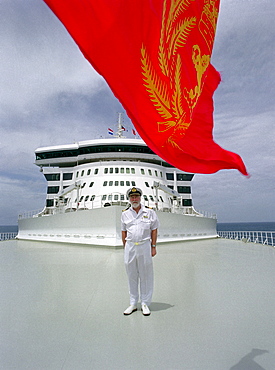 Commodore Ronald Warwick standing on the deck under a red flag, Cruise ship Queen Mary 2