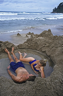 Young couple bathing in hot water on the beach, Coromandel Peninsula, North Island, Oceania