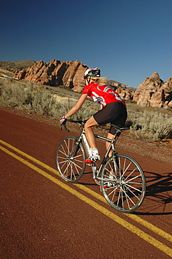 Woman on a racing bike through Zion National Park, Springdale, Utah, USA