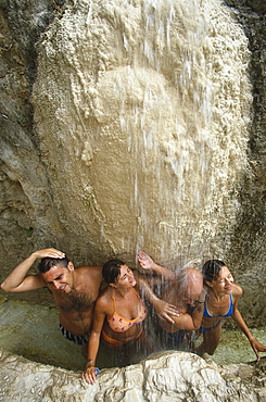 Four people enjoying the water of the thermal bath, Bagno Vignoni, Tuscany, Italy