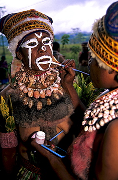 Woman painting the face of another woman in preparation for the Huli Sing Sing celebrations, Mt Hagen, Eastern Highlands, Papua New Guinea, Melanesia