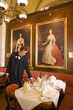 Waiter arranging setting on table at Cafe Central, Vienna, Austria