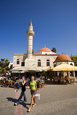 Two women passing pavement cafe near Defterdar-Mosque at Platia Eleftherias, Kos-Town, Kos, Greece