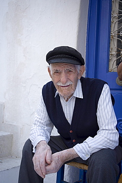 A local old man sitting in front of a white house, Mykonos-Town, Mykonos, Greece