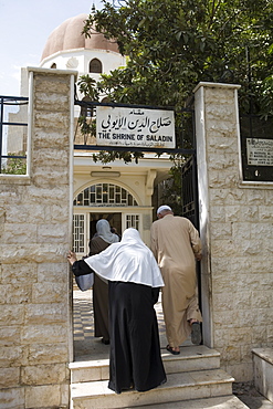 Women and man entering The Shrine of Saladin Mausoleum, Damascus, Syria. Asia