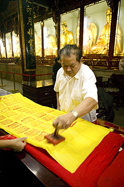 Mature man stamping contribution receipt for pilgrims, Puji Si monastery, Putuo Shan Island, Zhejiang Province, China, Asia