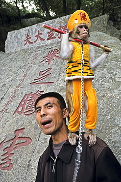 Man with performing monkey, Monkey is dressed up as the monkey king Sun Wukong, Mount Tai, Tai Shan, Shandong province, World Heritage, UNESCO, China