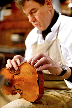 Man reparing a violin, Antique Violin repair shop, Old Town, Prague, Czech Republic