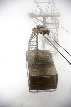 Cabin of the Schilthornbahn in fog on the way to Piz Gloria and top station of the Schilthornbahn (location for James Bond novel and film On Her Majesty's Secret Service), Schilthorn (2970 m), near Muerren, Bernese Oberland (highlands), Canton of Bern, Switzerland