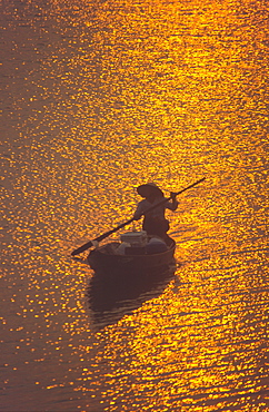 Vietnam, Nha Thrang, river dalta at sunset, woman on a fisherboat