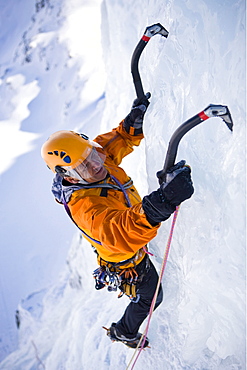 A man ice climbing on on a frozen waterfall, Corn Diavolezza near Pontresina, Grisons, Switzerland