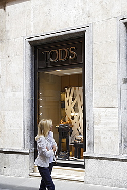 Woman passing a shop window at Via Condotti, Rome, Italy