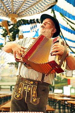 Man wearing bavarian costume playing melodeon