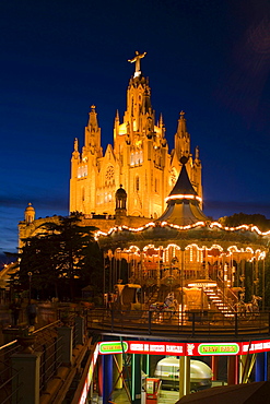 El Sagrat Cor, church, and carousel of the amusement park, Tibidabo, Barcelona, Catalonia, Spain