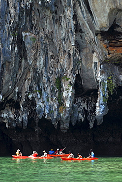 Canoe in front of limestone cliffs in the Bay of Phang Nga, Thailand