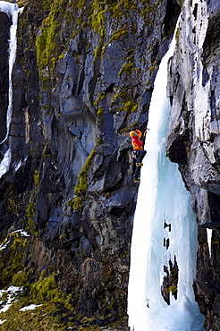 Ice climber on frozen waterfall, Iceland