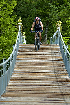 Mountainbiker on suspension bridge, Slovenia