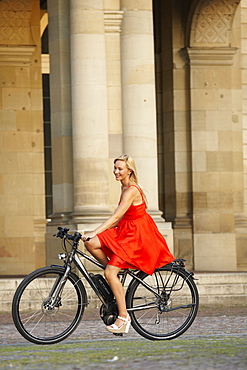 Woman cycling on an e-bike, bike tour, Schlossplatz, New Castle, Stuttgart, Baden-Wurttemberg, Germany