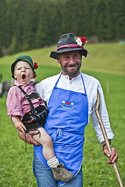 Farmer and son wearing traditional clothes, drive fromthe mountain pastures, Almabtrieb, Ulten valley, South Tyrol, Italy