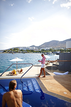 Man and woman at the pool and deck of the Yachting Club Villas, Elounda Beach Resort, Elounda, Crete, Greece