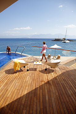 Man and woman at the pool and deck of Yachting Club Villas, Elounda Beach Resort, Elounda, Crete, Greece