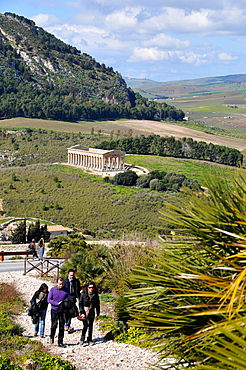 Four tourists with the view onto the Temple of Segesta in the background, Trapani, Sicily, Italy