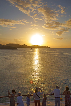 People standing at the railing of cruise ship MS Deutschland (Reederei Peter Deilmann) and admiring the sunset, near St. John's, St. John, Antigua, Antigua and Barbuda, Caribbean