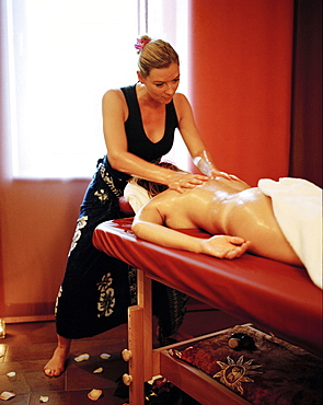 Woman enjoying traditional Hawaiian massage Lomi Lomi Nui in a spa resort, Travemuende, Luebeck, Schleswig-Holstein, Germany