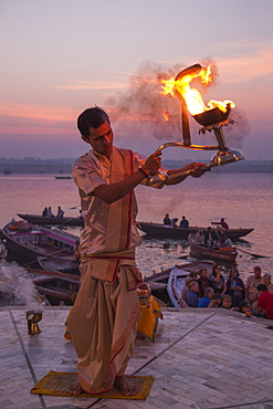 Hindu monk performs prayer ceremony at Dasaswamedh Ghat alongside Ganges river at sunrise, Varanasi, Uttar Pradesh, India