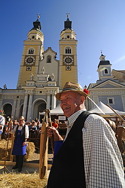 Man threshing corn, Harvest festival on cathedral square, Brixen, South Tyrol, Italy