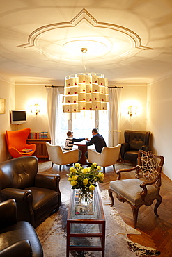 Father with son in the lounge of Hotel Haus Hirt, Bad Gastein, St. Johann im Pongau, Salzburg, Austria