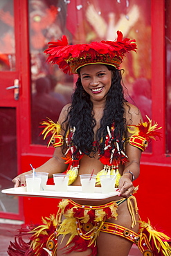 Cheerful woman serving drinks at Miscigenacao dance and folklore show with Boi Bumba festival costumes, Parintins, Amazonas, Brazil