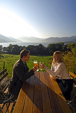 Young couple at a beer garden in the sunlight, lake Tegernsee, Bavaria, Germany, Europe