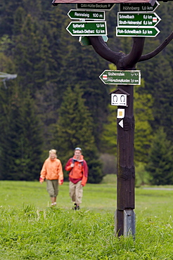 Couple hiking in theThuringian Forest, Signpost, near Tambach Dietharz, Thuringia, Germany